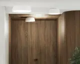 Nowoczesne wnętrze z drewnianymi panelami i dwoma białymi lampami sufitowymi.