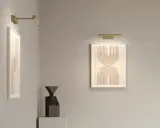 Nowoczesna lampa galeryjka podkreśla abstrakcyjne obrazy i rzeźbę w minimalistycznym wnętrzu.